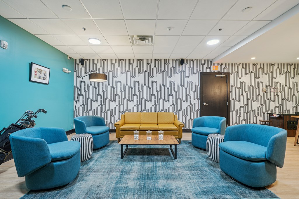 a waiting room with blue chairs and a yellow couch