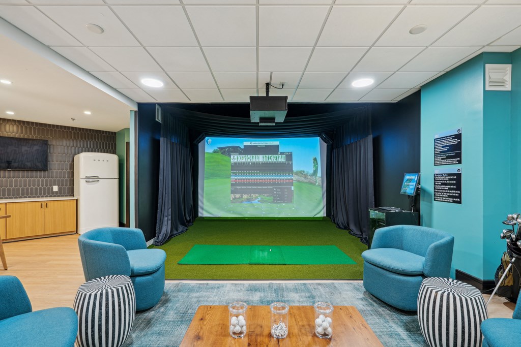 a room with a projector screen and chairs and a table