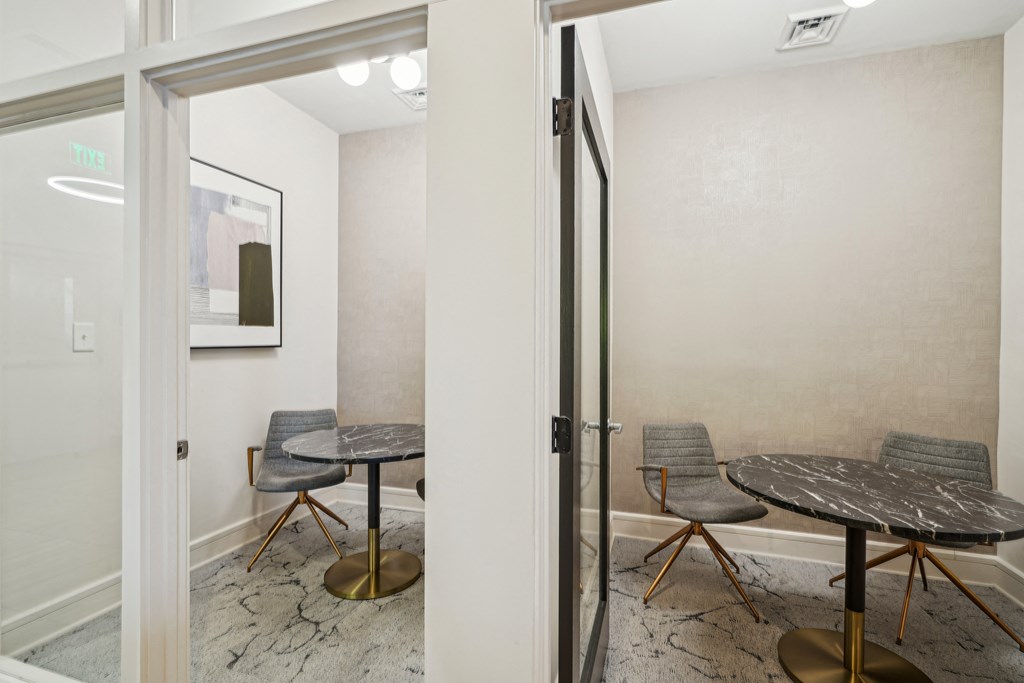 a meeting room with a table and chairs and a glass door
