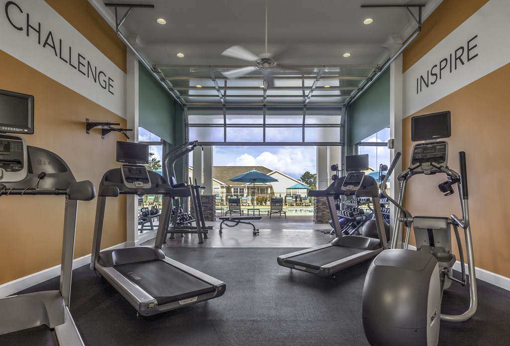interior community fitness center overlooking pool area