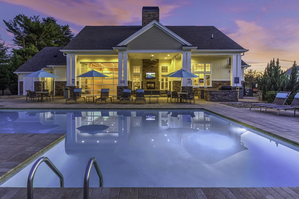 exterior community pool with seating at dusk