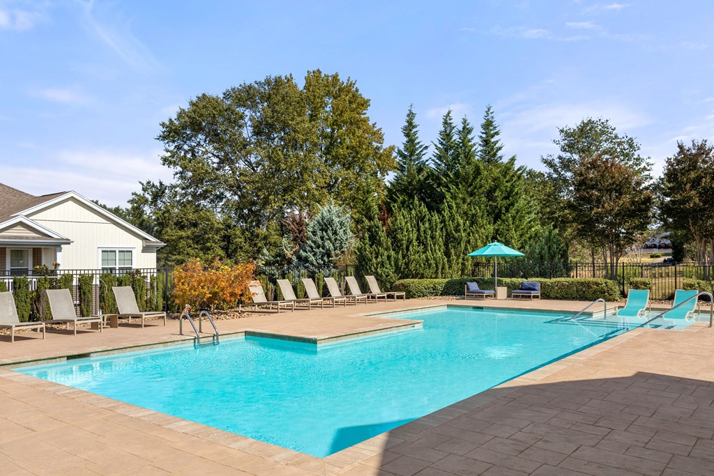 the swimming pool at our apartments with chairs around it