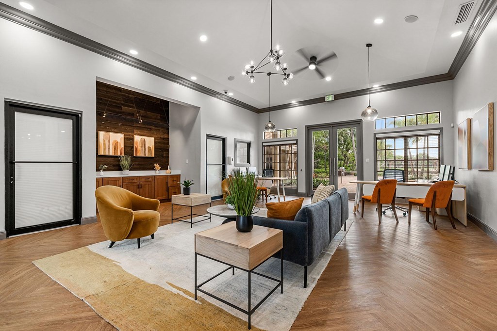 A modern room with a sofa, chairs, and a table with a green plant.