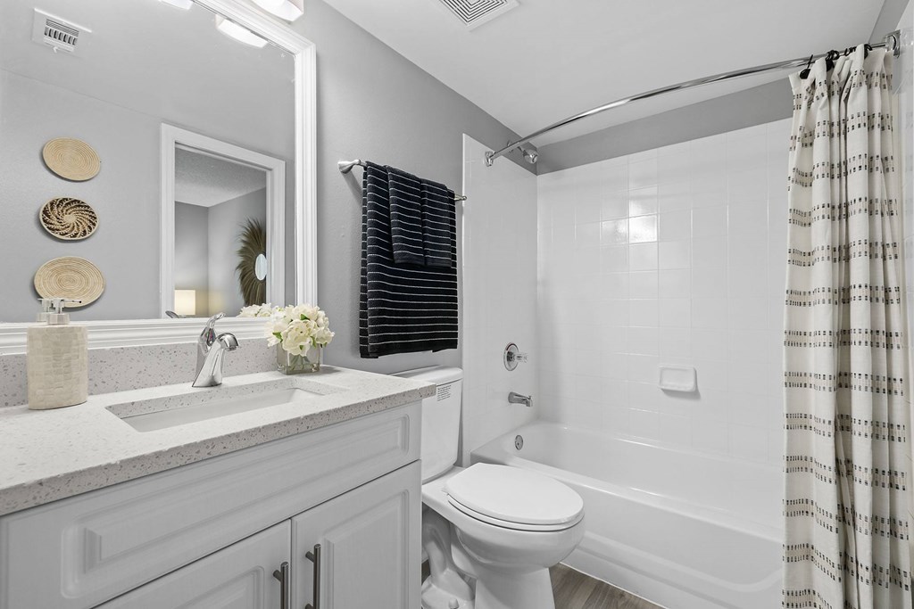 A white bathroom with a toilet, sink, and bathtub.