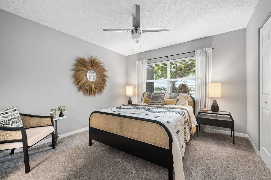 A bedroom with a bed, a bench, and a wall decoration.