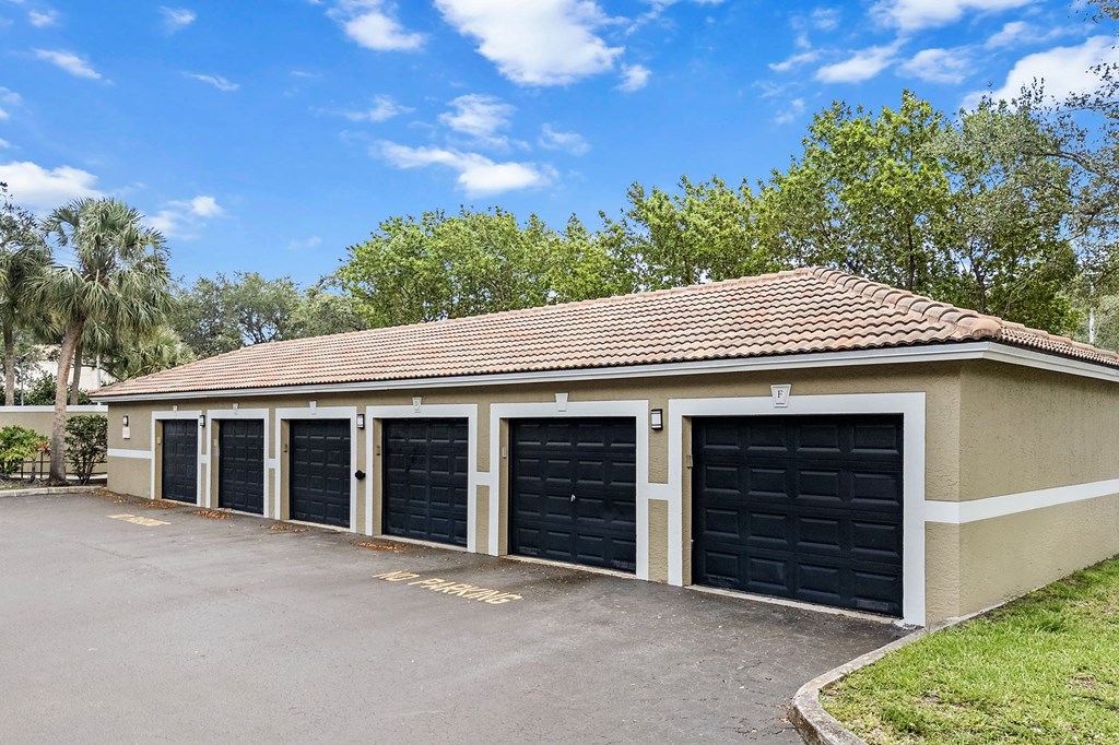 A building with a brown roof and black garage doors.