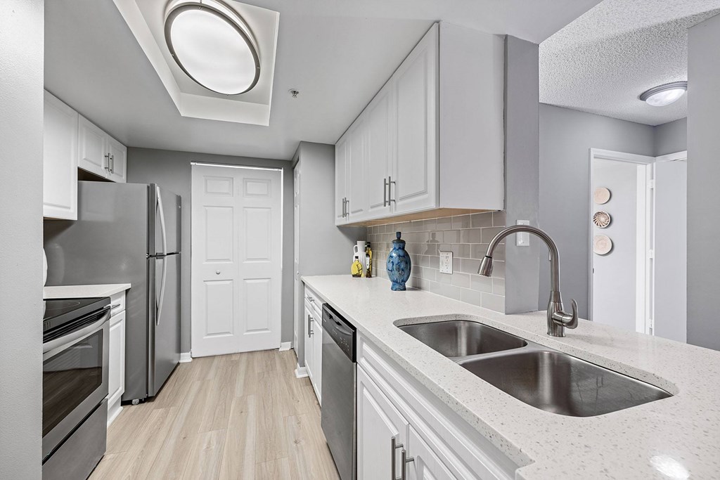A kitchen with a sink, stove, and refrigerator.