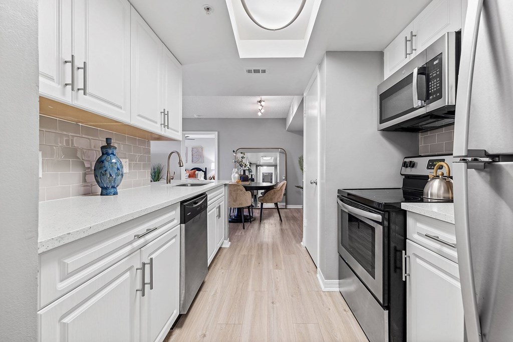 A kitchen with white cabinets and a black stove top oven.
