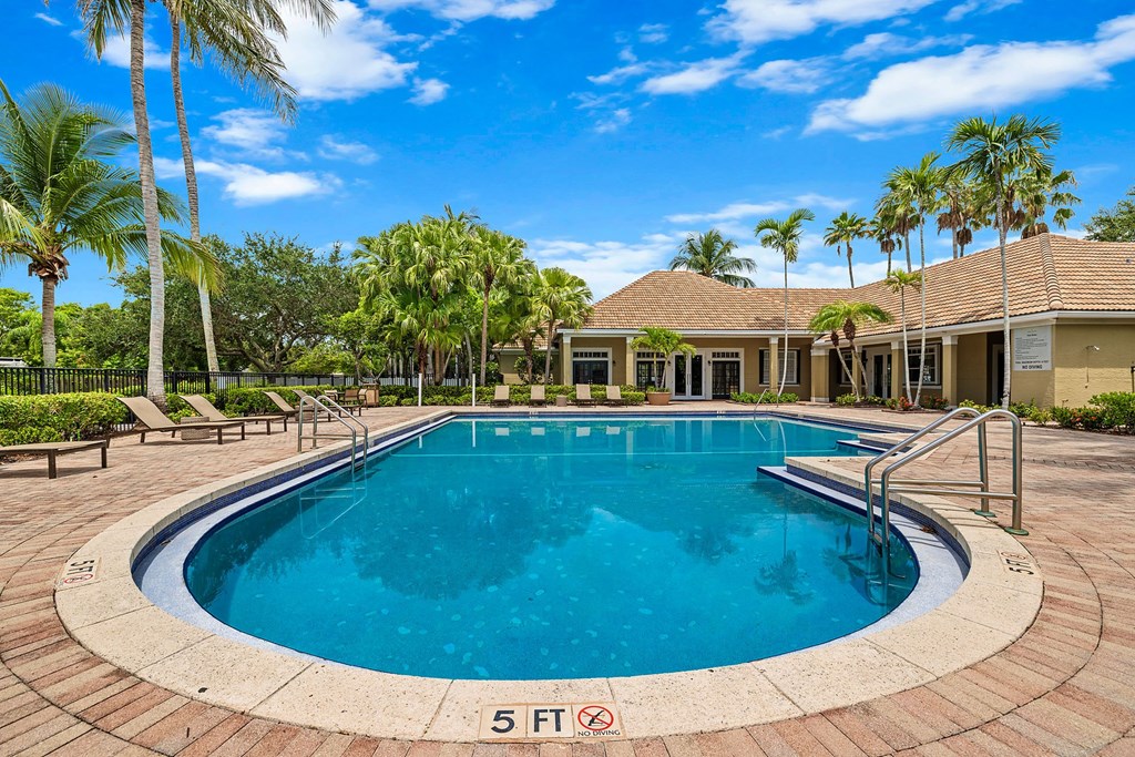 A round swimming pool surrounded by a brick border with a 5 ft sign on the ground.