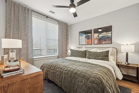 A bedroom with a large bed and a ceiling fan.