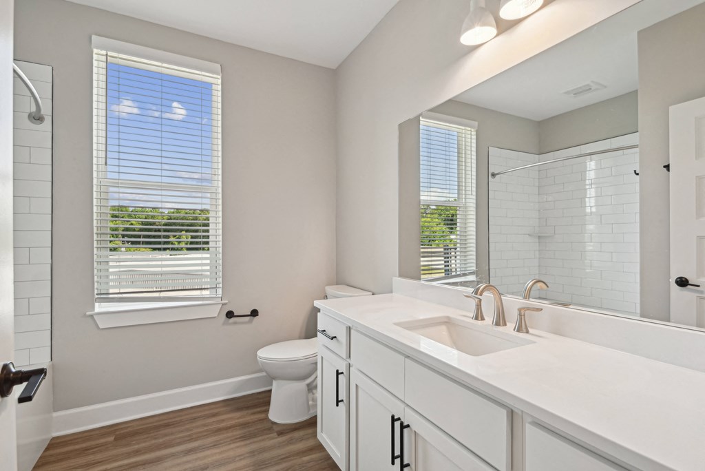 a bathroom with a large mirror and a toilet and a sink