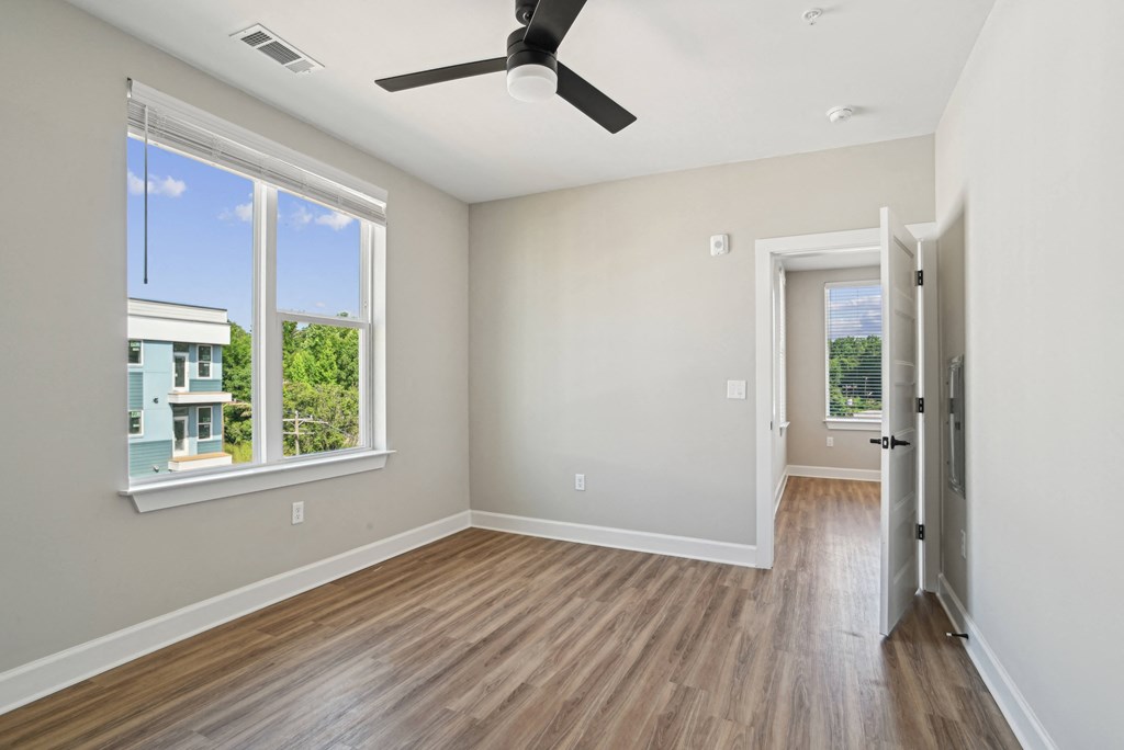 an empty room with wood floors and a ceiling fan