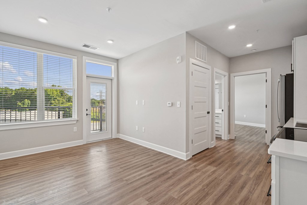 a living room with a large window and a door to a kitchen