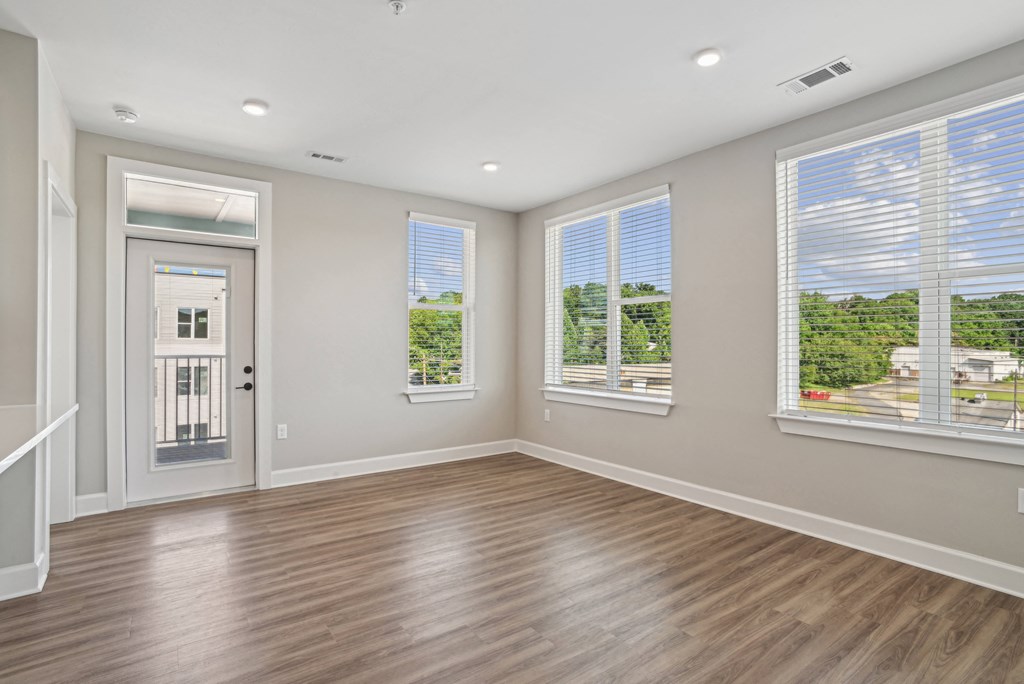 an empty living room with windows and a door