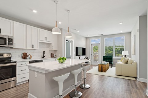 A modern kitchen with white cabinets and a large island.