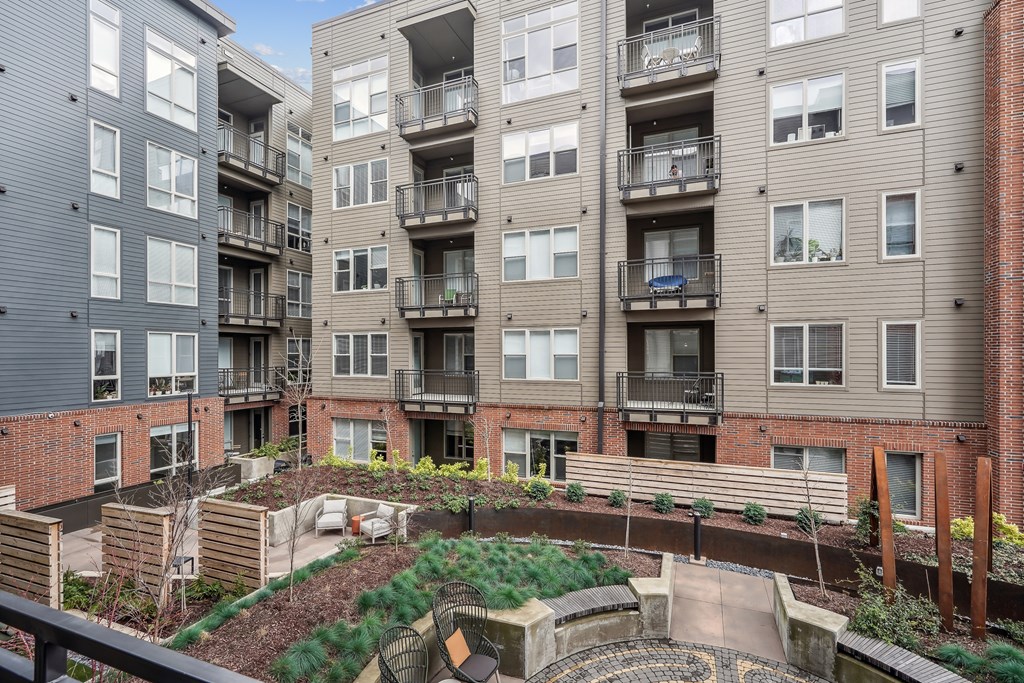 view of an apartment building with a fenced in courtyard