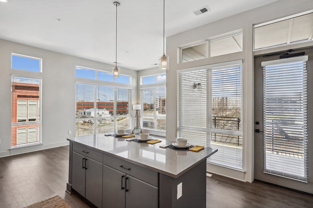 an open kitchen with large windows and a large island in the middle