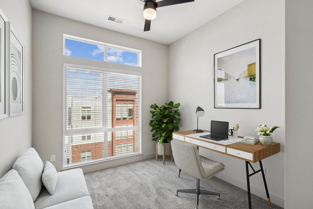 an office with a large window and a desk with a computer