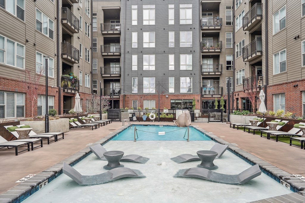 an apartment with a swimming pool in front of an apartment building