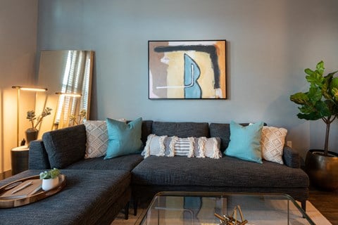 a living room with blue walls and a couch with blue pillows