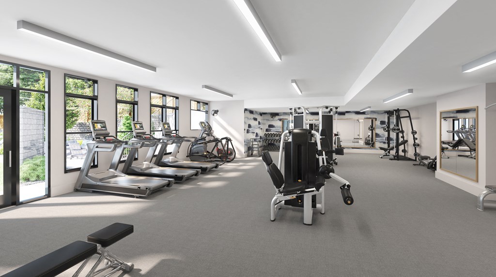 a gym with cardio equipment and windows in a building