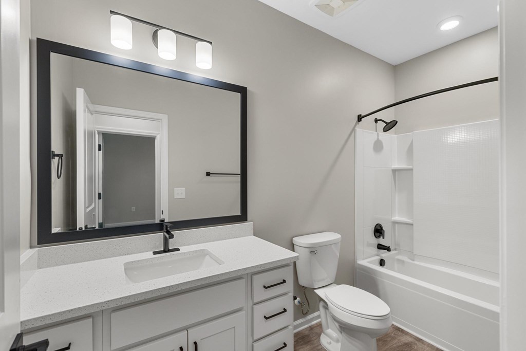 A white bathroom with a sink, toilet, and bathtub.