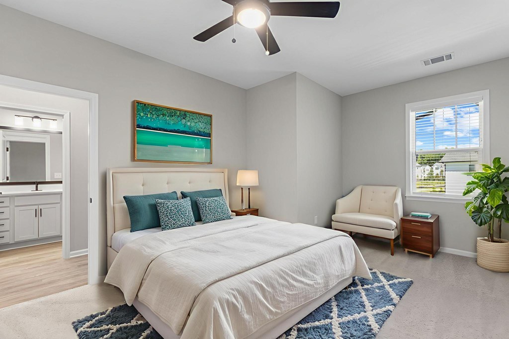 A bedroom with a large bed and a ceiling fan.