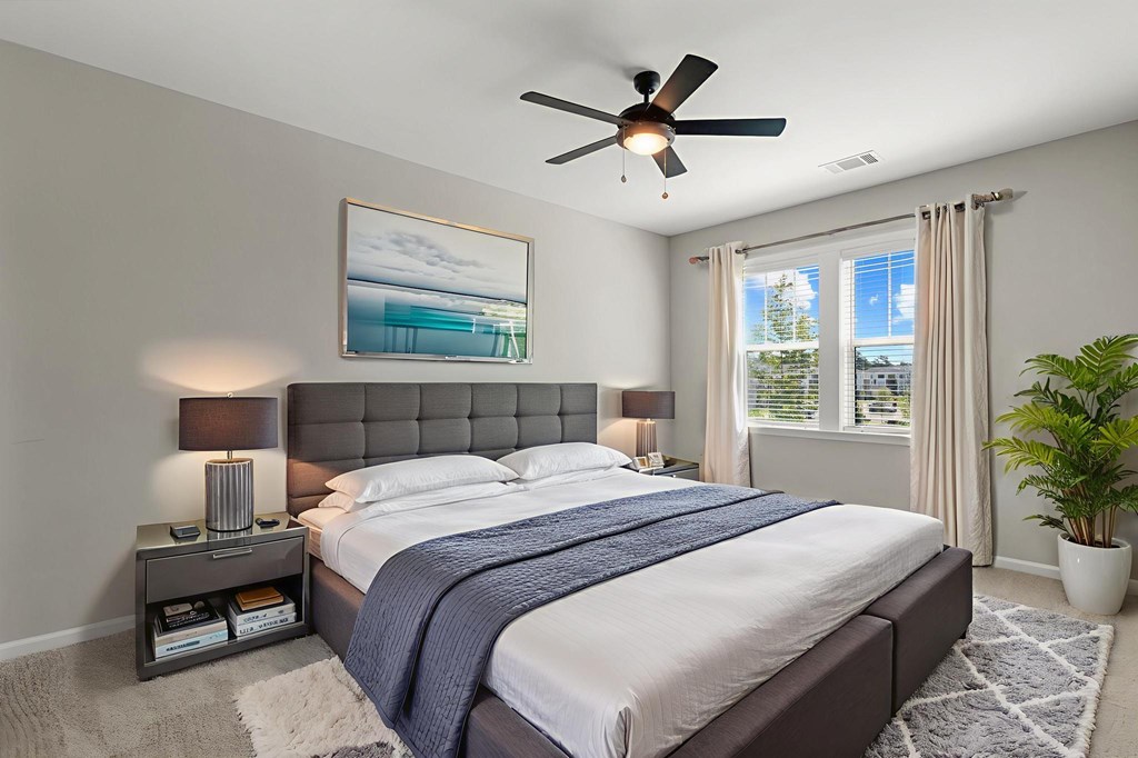A bedroom with a large bed and a ceiling fan.