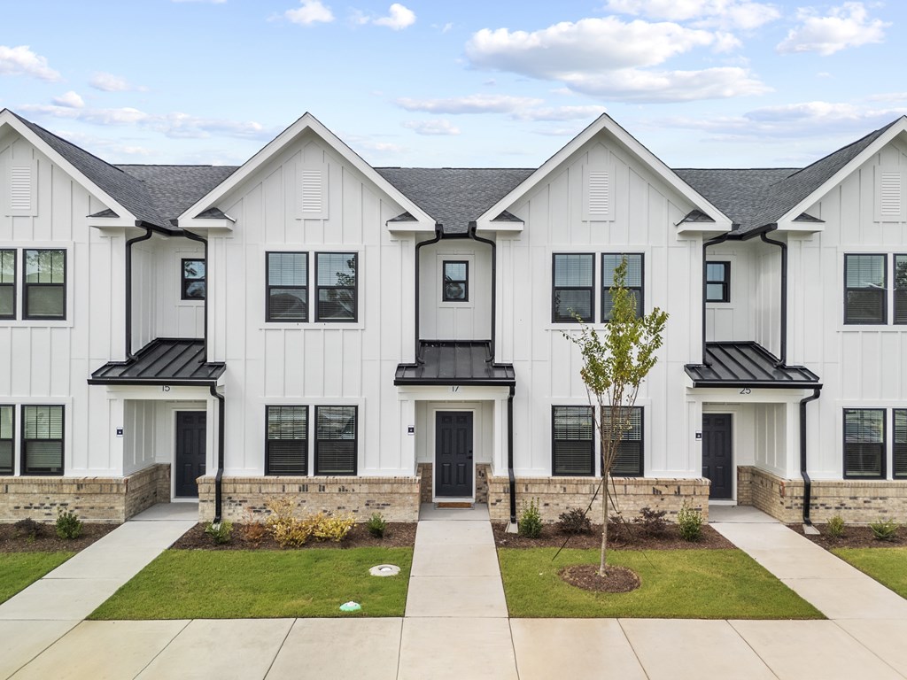 White buildings with black roof and green grass.