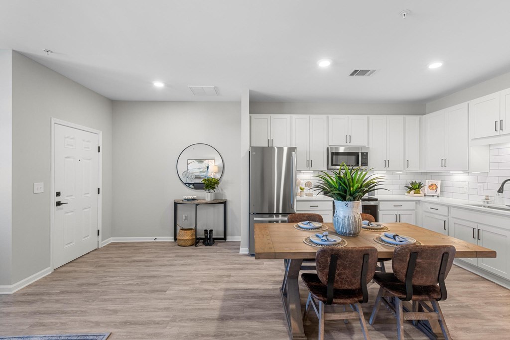 A modern kitchen with a dining table set for two.