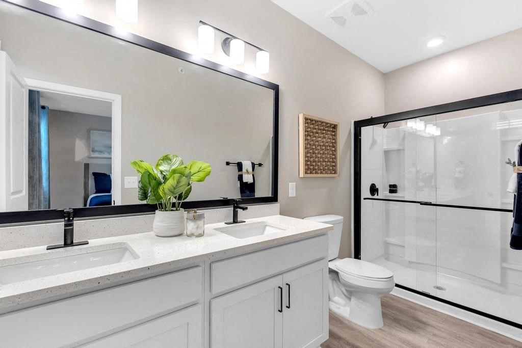 A bathroom with a white countertop and a large mirror above it.
