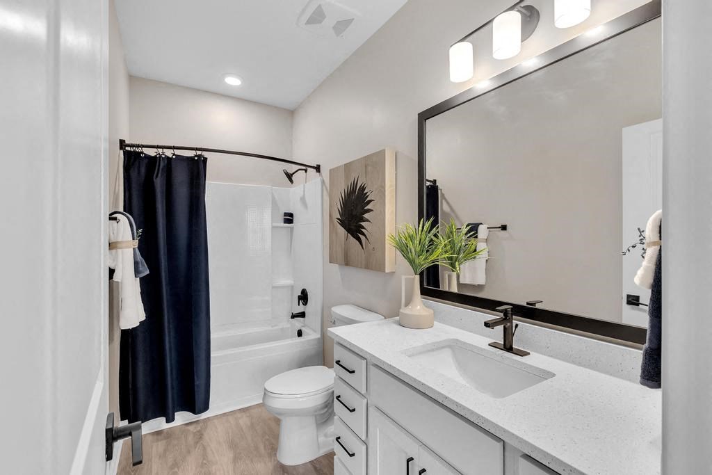A bathroom with a white toilet, sink, and a mirror.