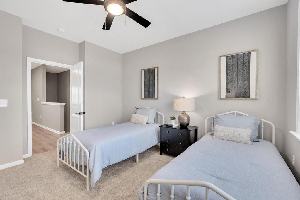 a bedroom with two beds and a ceiling fan