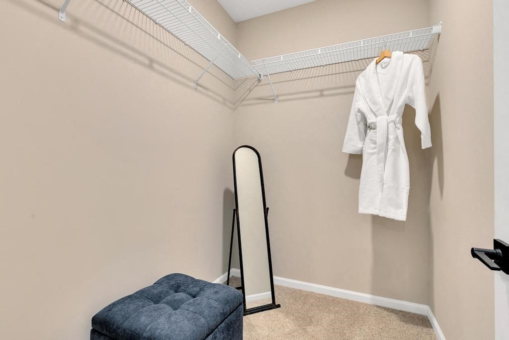 a closet with a mirror and a robe hanging on the wall