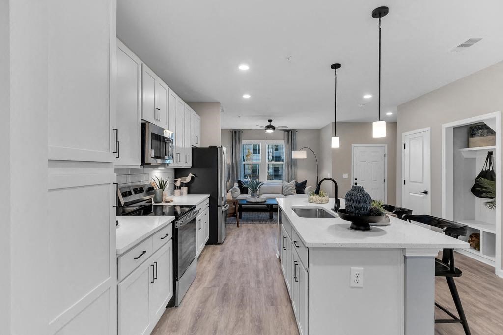 A modern kitchen with white cabinets and a large island.