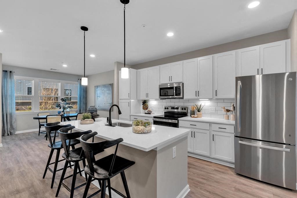 A modern kitchen with a large island and stainless steel appliances.