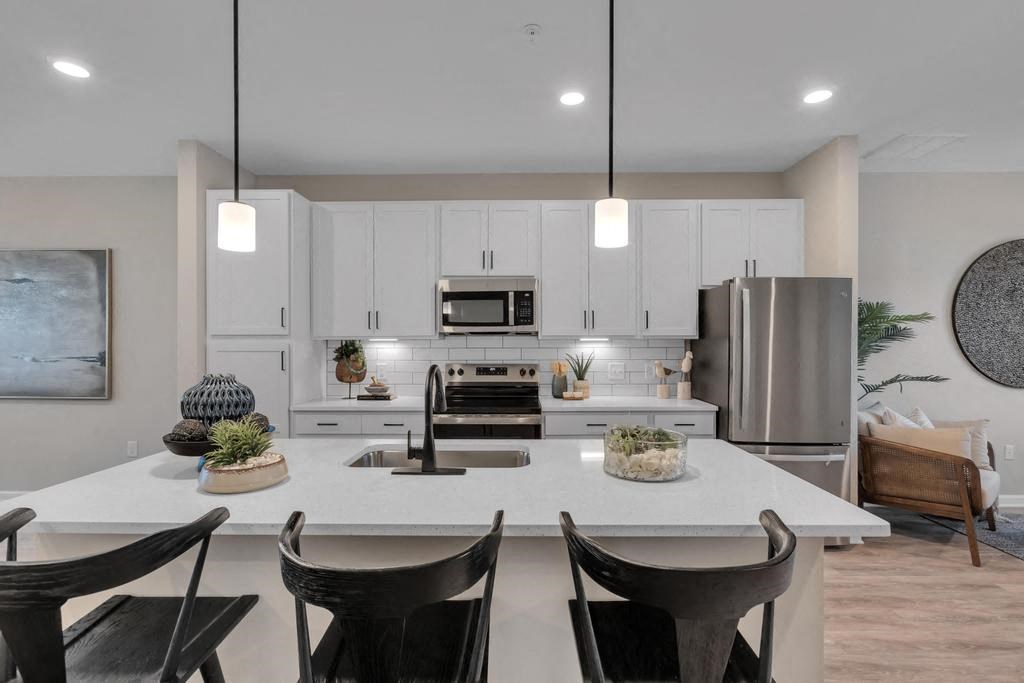 A modern kitchen with a large island and chairs.