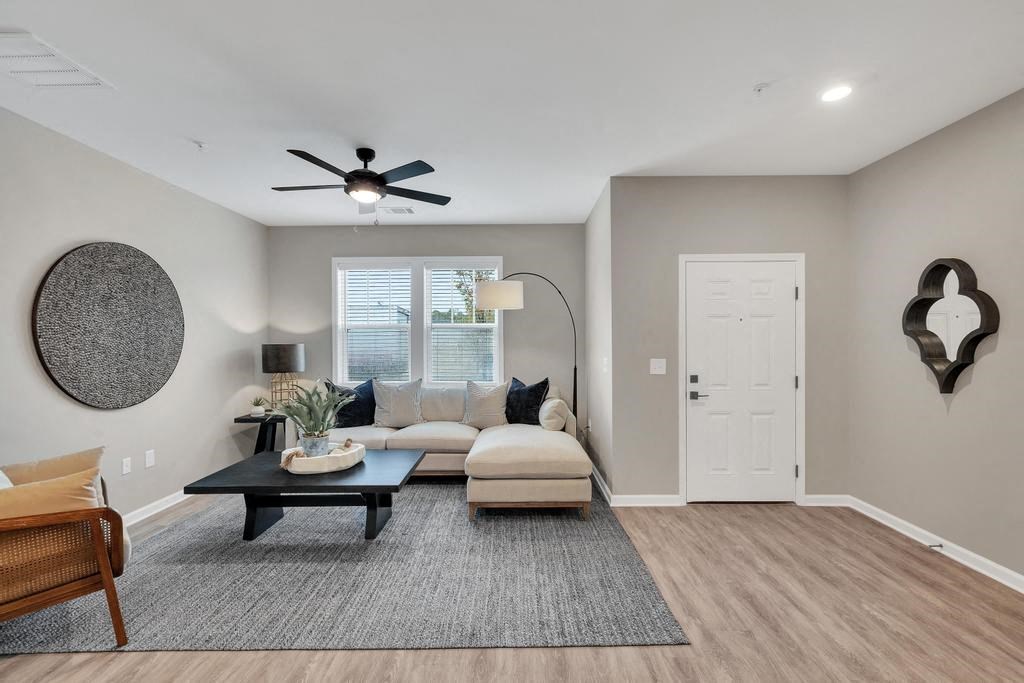 a living room with a couch and a ceiling fan