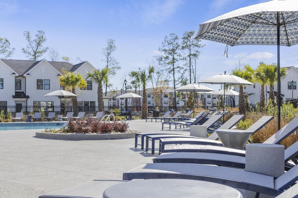 A poolside area with lounge chairs and umbrellas.