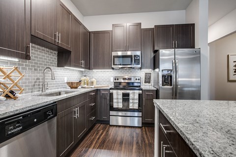 a kitchen with stainless steel appliances and marble counter tops