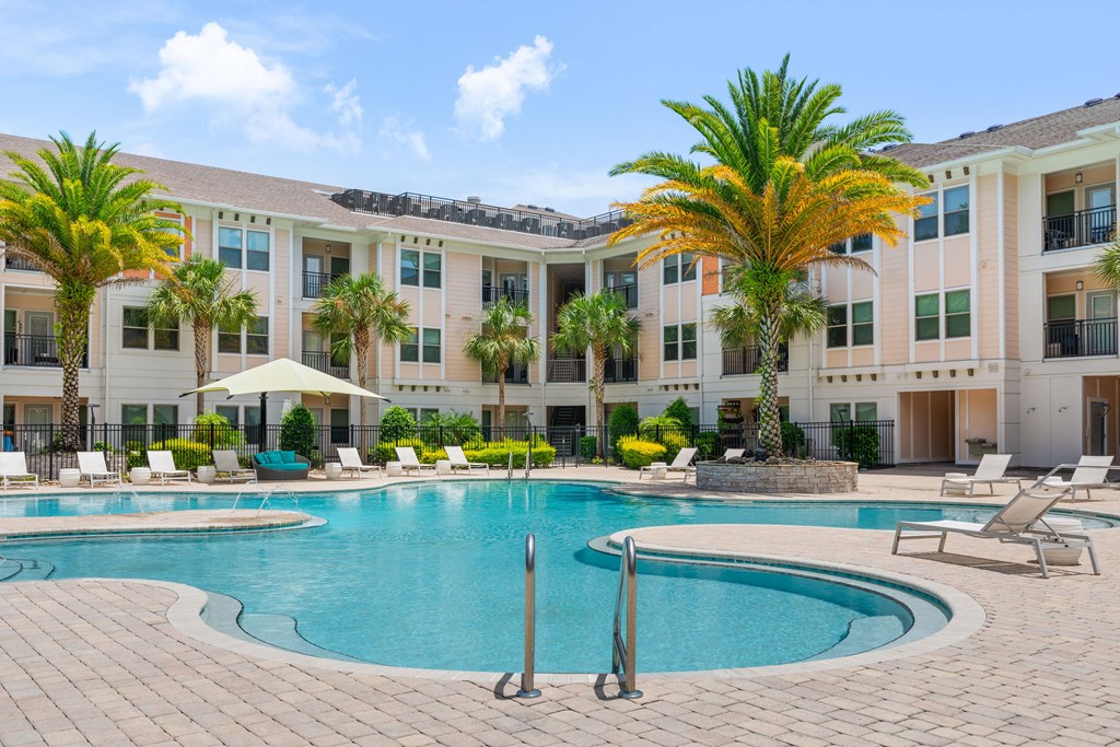 a large swimming pool in front of an apartment building