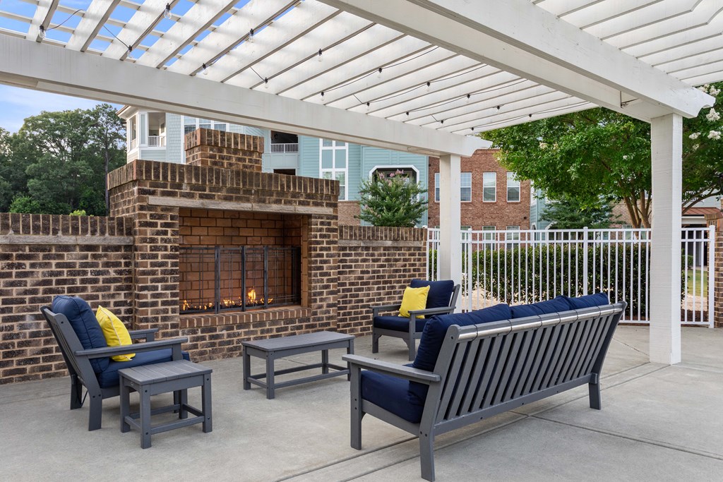 a patio with a fireplace and a pergola