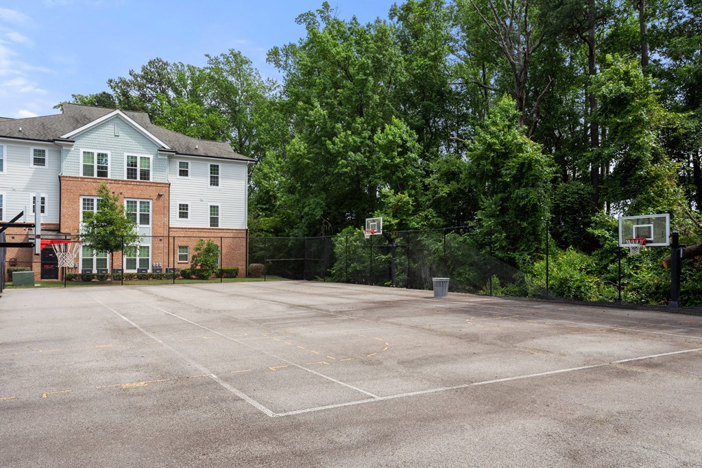 a large basketball court with trees in the background