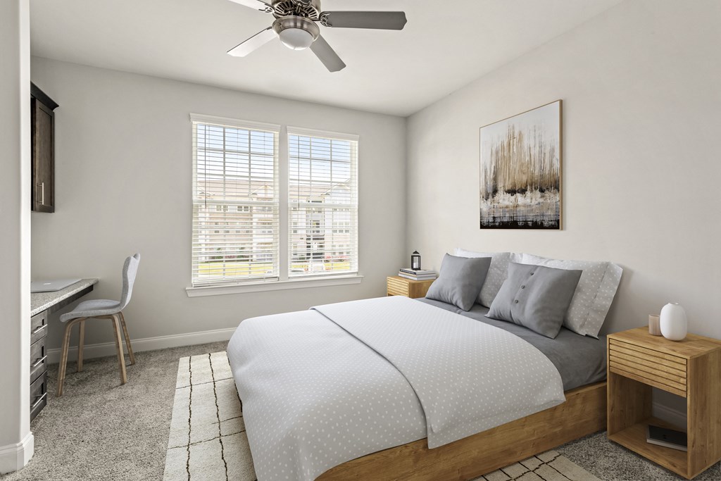 A bedroom with a bed, a chair, a table, and a painting on the wall.
