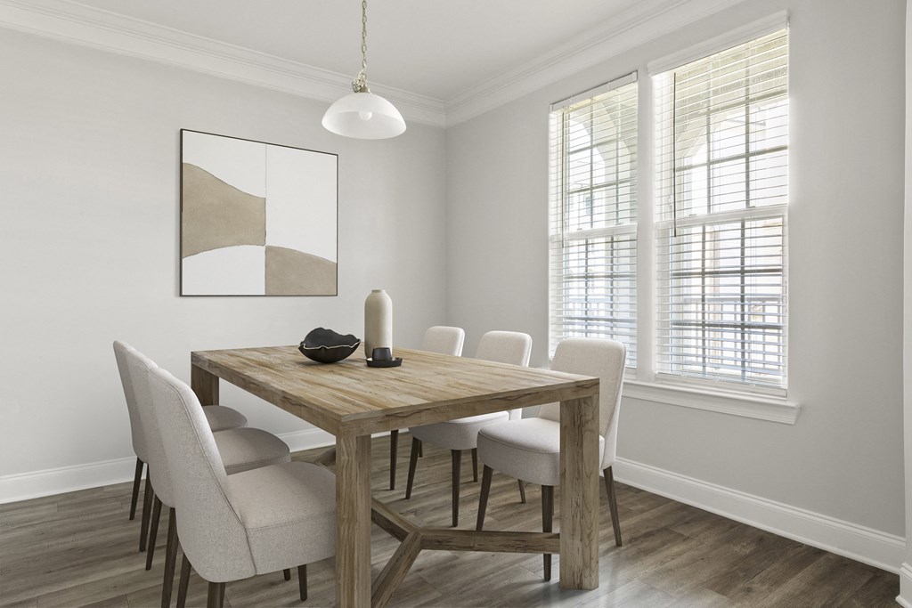 A dining table with chairs and a painting on the wall.