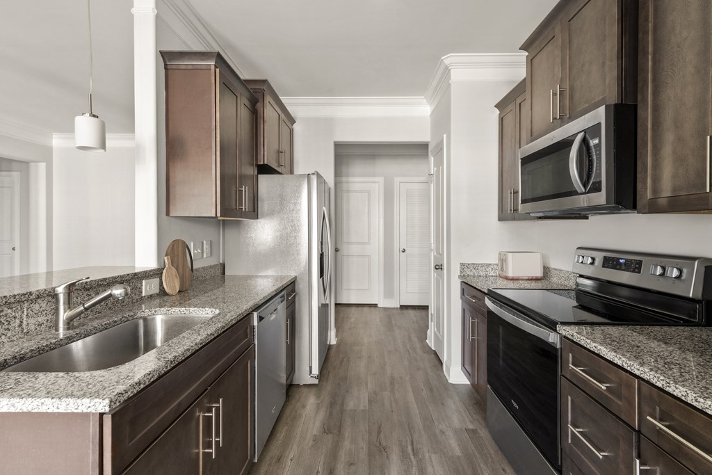 A kitchen with dark wood cabinets and stainless steel appliances.