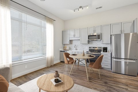 A modern kitchen with a dining table and chairs.