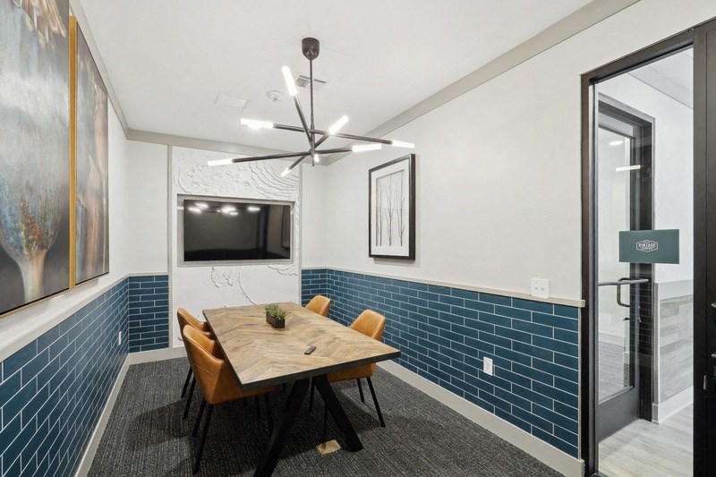 a conference room with a table and chairs and a television
