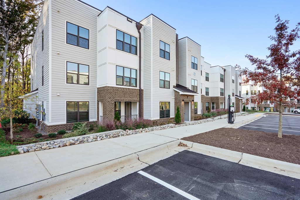 a row of apartment buildings with a sidewalk in front of them