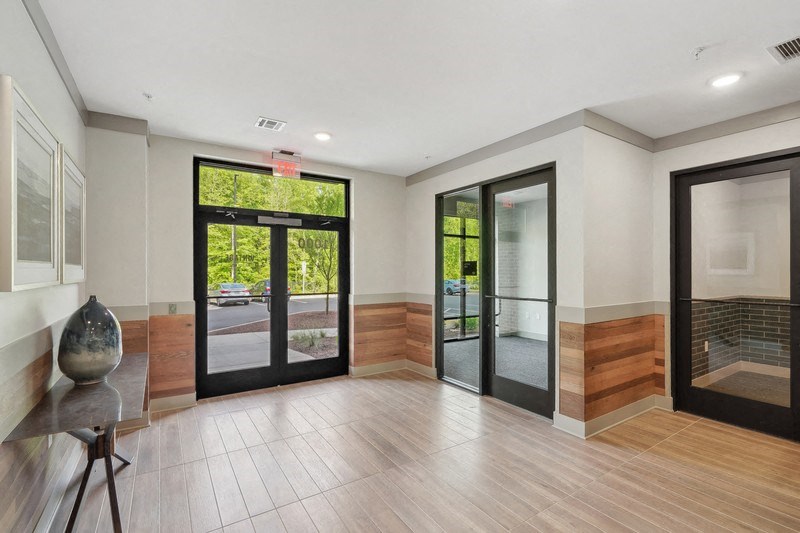 the living room is open to the entryway and has a large glass door and